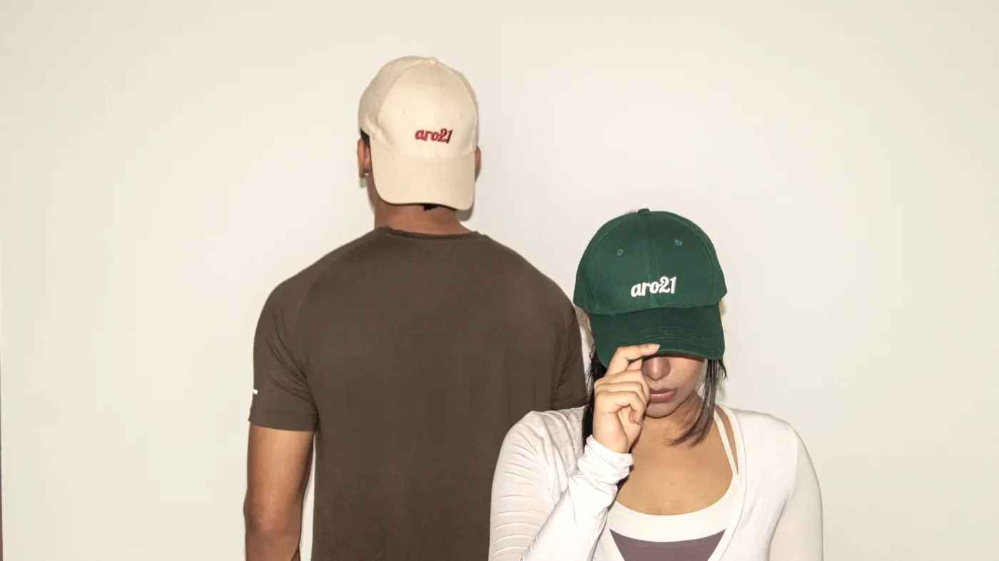 Two people wearing the aro21 cap, one in Dawn cream and one in Grove green